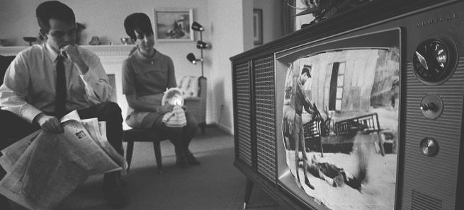 casal vê imagens da guerra do vietname na televisão