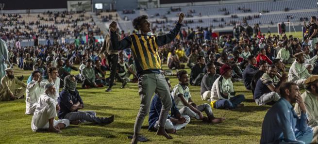 Trabalhadores migrantes a verem um jogo do Mundial no Qatar